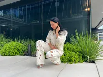 Pantalón blanco roto de corte recto con detalles de calados florales en las piernas.