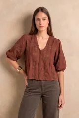 Blusa de encaje color marrón con escote en V, mangas tres cuartos abullonadas y calce oversize.