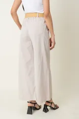 Pantalón ancho color verde oliva, de algodón y spandex, con cintura elastizada, cinto rústico y bolsillos laterales.