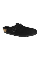 Zueco negro de gamuza con forro de piel de oveja y hebilla ajustable.