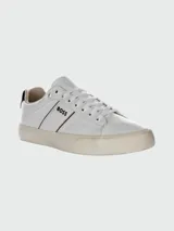 Championes de piel sintética blancos, estilo tenis de caña baja, con cordones blancos y suela de goma color crema. Presentan el logo "BOSS" en el lateral con una línea marrón y negra.