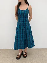 Vestido midi azul a cuadros con tirantes finos, escote redondo y cuerpo fruncido.