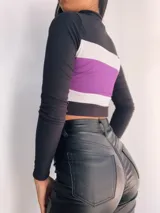 Top manga larga con cierre frontal y diseño tricolor con franjas horizontales en negro, blanco y rojo, fucsia, violeta o azul.