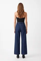 Pantalón de jean azul oscuro, de tiro alto y corte wide leg, con pinzas en la parte delantera.