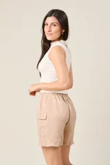 Short color beige con cintura elástica ajustable con cordón, bolsillos laterales y bolsillos cargo con solapa en los muslos.