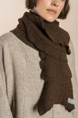 Bufanda tejida en punto fantasía con textura cuadriculada y bordes con efecto de volado. Confeccionada en lana fina sin teñir.