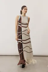 Vestido largo de punto con diseño geométrico y de ondas en color negro y crudo, sin mangas, con escote halter y detalle de flecos en el ruedo.