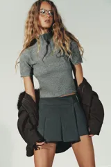 Jersey de punto suave con cuello subido y manga corta, con acabados en vuelta en los bordes.