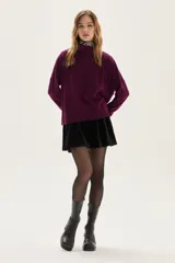 Polera de tejido de punto color azul, con cuello alto, manga larga y puños acanalados.