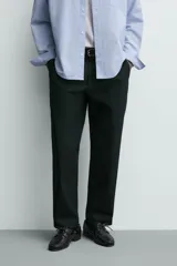 Pantalón de corte regular fit confeccionado en tejido mezcla de algodón. Presenta cintura con detalle de pliegues en el delantero, bolsillos frontales y bolsillos traseros de vivo con botón. Cierre frontal con cremallera y botón.