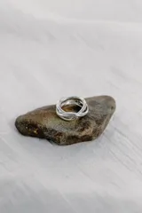 Anillo de diseño artesanal con estructura entrelazada de líneas irregulares y acabado orgánico. Pieza ajustable fabricada en metales nobles.
