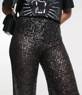 Pantalón largo de lentejuelas negras metalizadas con forro y cintura elástica.