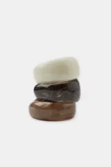 Pack de tres pulseras rígidas de resina con acabado marmolado en tonos crema, marrón oscuro y marrón claro.