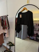 Top negro corto con mangas largas tipo murciélago.