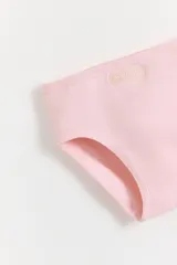 Pack de tres bombachas tipo vedetina de algodón con cintura elástica y etiqueta de la marca. Incluye una unidad lisa en color gris melange, una unidad lisa en color rosa y una unidad blanca con estampado de corazones rojos y rosados.
