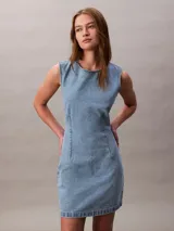 Vestido corto de denim sin mangas con cuello redondo, diseño de espalda abierta y pinzas frontales para un ajuste entallado.
