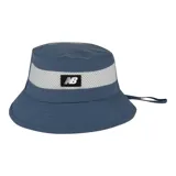 Gorro tipo bucket New Balance color azul, con una franja de malla gris en la parte superior y un parche rectangular negro con el logo de la marca en el frente.