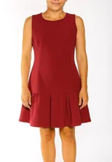 Vestido corto color borgoña, sin mangas, con cuello redondo y falda con volados.