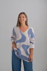 Sweter de punto con diseño de ondas abstractas en tonos azul y beige, escote en V y mangas largas con puños doblados.