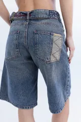 Bermuda de jean tiro alto, color azul con efecto lavado, corte holgado y diseño clásico de cinco bolsillos.