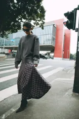 Falda midi de tiro alto ZARA Woman Collection, con diseño evasé y estampado de cuadros en tonos oscuros con líneas rojas y blancas. Cuenta con cierre lateral con cremallera oculta.