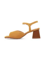 Sandalias de taco cuadrado y punta cuadrada de cuero gamuza mostaza, con escote en V en el empeine y tira ajustable con hebilla en el tobillo.