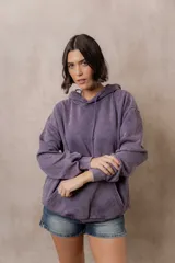 Canguro oversize fucsia con efecto washed, capucha con cordones ajustables al tono, bolsillo frontal tipo canguro y terminaciones de rib en puños y cintura.
