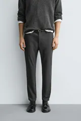 Pantalón de corte slim fit confeccionado en tejido elástico, con cintura elástica, cierre frontal con cremallera y botón, bolsillos laterales y bolsillos traseros de vivo.
