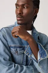 Campera de jean Levi's modelo Relaxed Fit Trucker, en color azul lavado. Presenta un diseño clásico con cuello camisero, cierre frontal con botones metálicos, dos bolsillos con solapa en el pecho y costuras reforzadas.