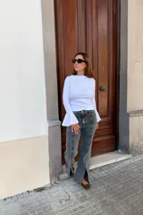 Remera blanca de manga larga con diseño oxford, confeccionada en algodón. Presenta un corte ajustado al cuerpo con mangas acampanadas y cuello redondo.