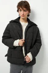 Campera negra capitoneada de manga larga, con bolsillos laterales con cierre y cuello de tela.