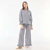 Pijama de dos piezas confeccionado en popelina con estampado de cuadros vichy. Incluye una camisa de manga larga con cuello camisero, cierre frontal de botones y puños con volados, y un pantalón de corte recto con terminación de volado en el ruedo.