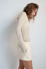 Body de encaje color marrón, con cuello redondo, manga larga y espalda descubierta.