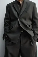 Blazer de corte relajado confeccionada en lana de origen italiano, con diseño de doble botonadura cruzada. Presenta cuello con solapas de muesca, manga larga con botones en puños, bolsillos con solapa en la cadera y abertura central en la espalda. Incluye forro interior a contraste.