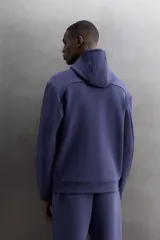 Campera canguro de Zara Athleticz, modelo relaxed fit, confeccionada en tejido técnico compacto elástico con mezcla de algodón en color azul marino. Cuenta con cuello subido con capucha, manga larga con bolsillo lateral con cierre, bolsillos frontales con cierre y acabado termofijado, cierre frontal de doble dirección y logo estampado en el bajo.