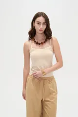 Musculosa de breteles finos confeccionada en poliamida, de corte ajustado al cuerpo y color beige.