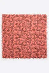 Chal rectangular color salmón con estampado de animales en negro y flecos en los bordes.