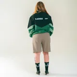 Campera deportiva unisex confeccionada en nylon liviano, color verde y negro, con calce relajado y estructura clásica. Incluye paneles diagonales en contraste y micrográfico Kaboa aplicados al frente y un gráfico en la espalda.