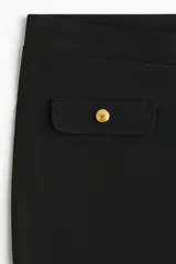 Pantalón acampanado de punto roma, color negro, con cintura elástica y solapas decorativas con botones dorados en la parte frontal.