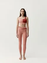 Calza deportiva color negro con detalle de banda blanca en la cintura y elástico cruzado, corte ajustado.