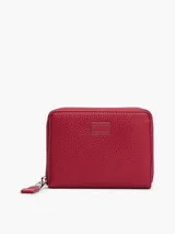 Billetera roja de cuero sintético con cierre perimetral y logo metálico de Tommy Jeans en el frente.