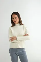 Polera negra de tejido de punto acanalado, con cuello alto y mangas largas.