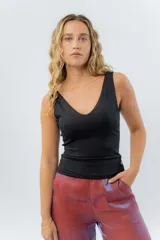 Top ajustado color gris claro, con escote en V pronunciado tanto en el frente como en la espalda, y tirantes anchos.