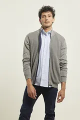 Cardigan de punto color azul marino, con cierre frontal de metal y cuello alto. Presenta tejido de punto fantasía y bolsillos laterales.