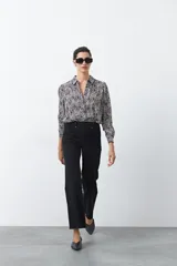 Pantalón de mujer color beige, de corte recto y tiro alto, con costuras frontales marcadas que recorren la pierna.