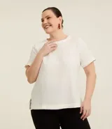 Blusa blanca de manga corta, con cuello redondo y detalle de pespuntes. Presenta un cierre trasero en forma de lágrima con botón y está confeccionada en tela texturizada de poliéster.