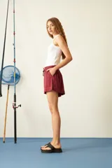 Short color borgoña de viscosa con cintura elástica ajustable con cordón, bolsillos laterales y corte holgado.