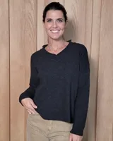 Sweater de punto color gris oscuro, con cuello en V y mangas largas de corte holgado.