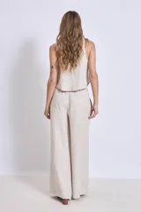 Pantalón de lino color beige, de corte amplio y tiro alto, con cintura elástica y bolsillos laterales.