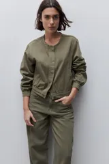 Pantalón jean de tiro alto con calce straight y pierna recta, confeccionado en denim de aspecto limpio. Cuenta con cinco bolsillos, cierre frontal con botón y presillas para cinturón.